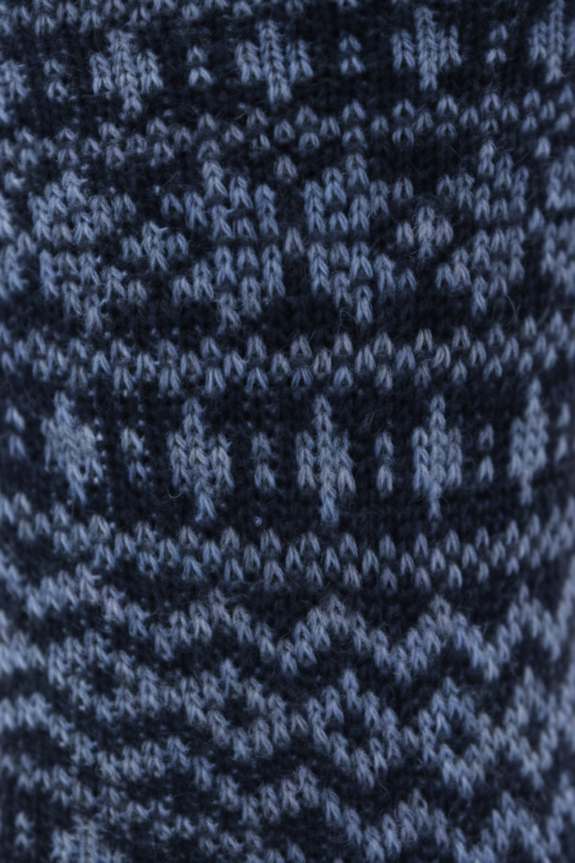 Close-up of a knitted textile with a dark navy and light blue Fair Isle pattern.