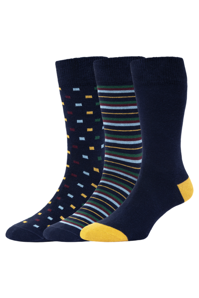 Three pairs of navy blue crew socks displayed together on a white background. One pair features small multicolored rectangular dots, the middle pair has thin multicolored horizontal stripes, and the front pair has a solid yellow toe and heel.