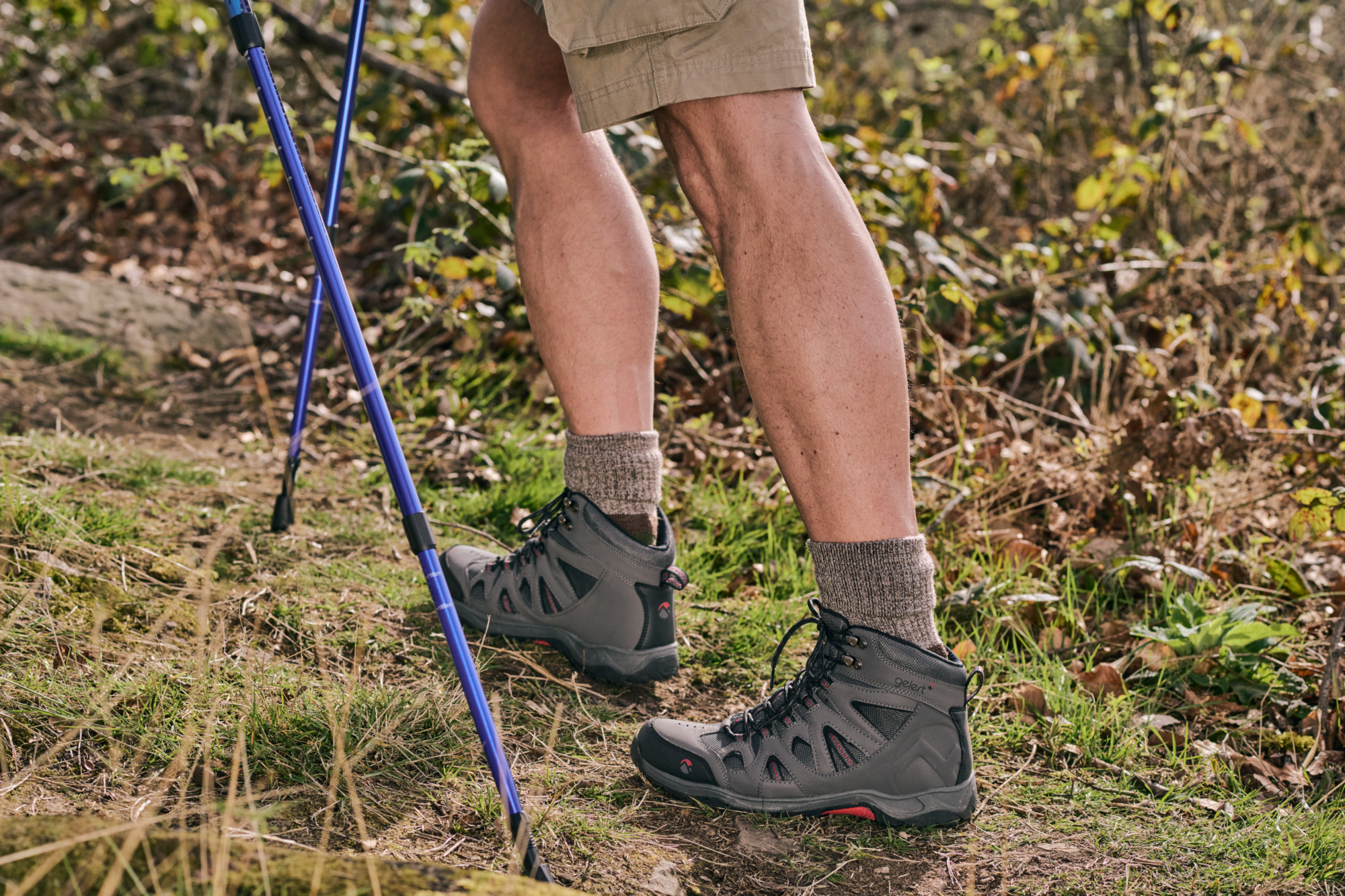 Person wearing hiking socks and boots and holding hiking poles on a trail