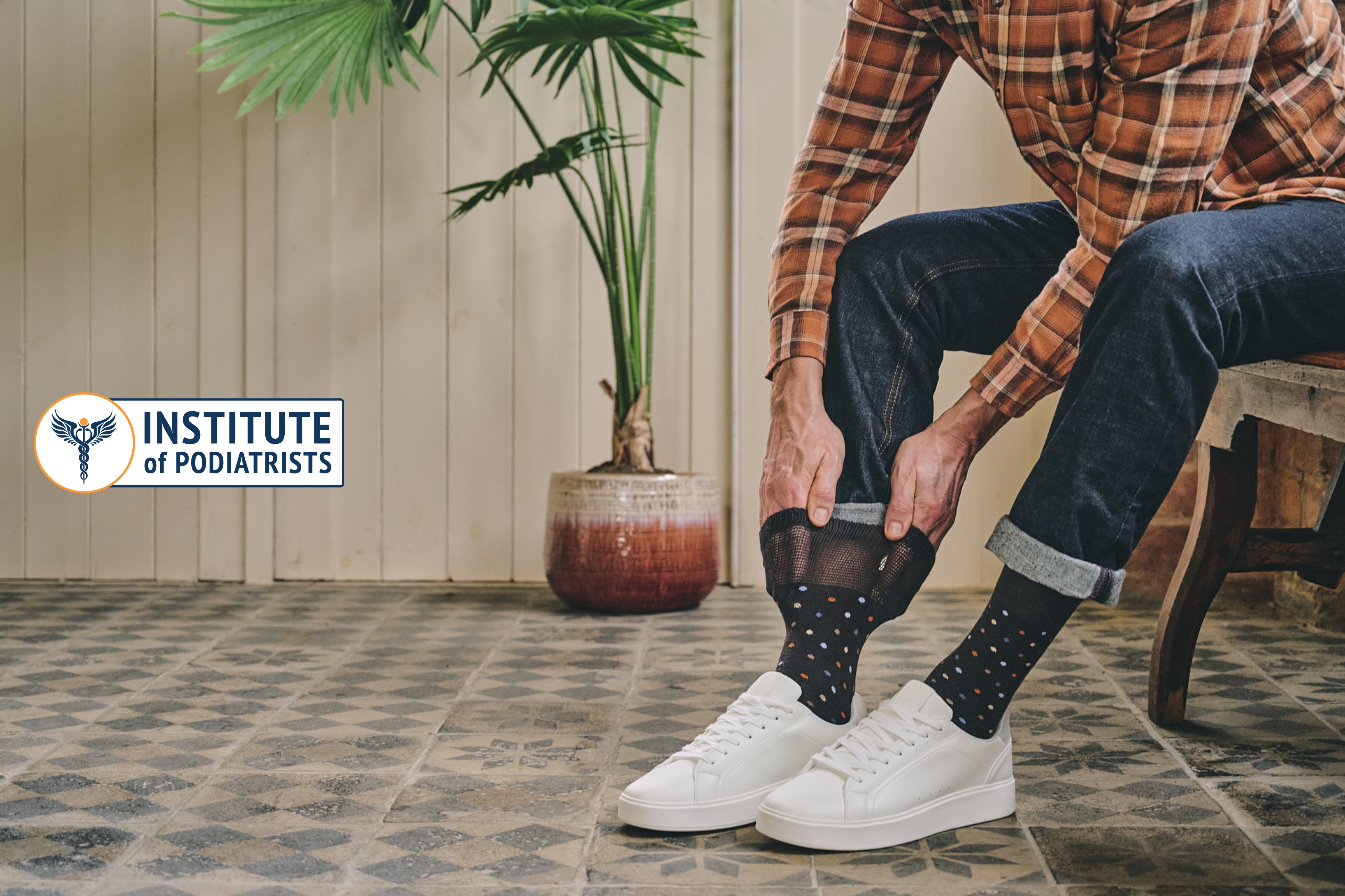 Person adjusting a sock with Institute of Podiatrists logo in the corner